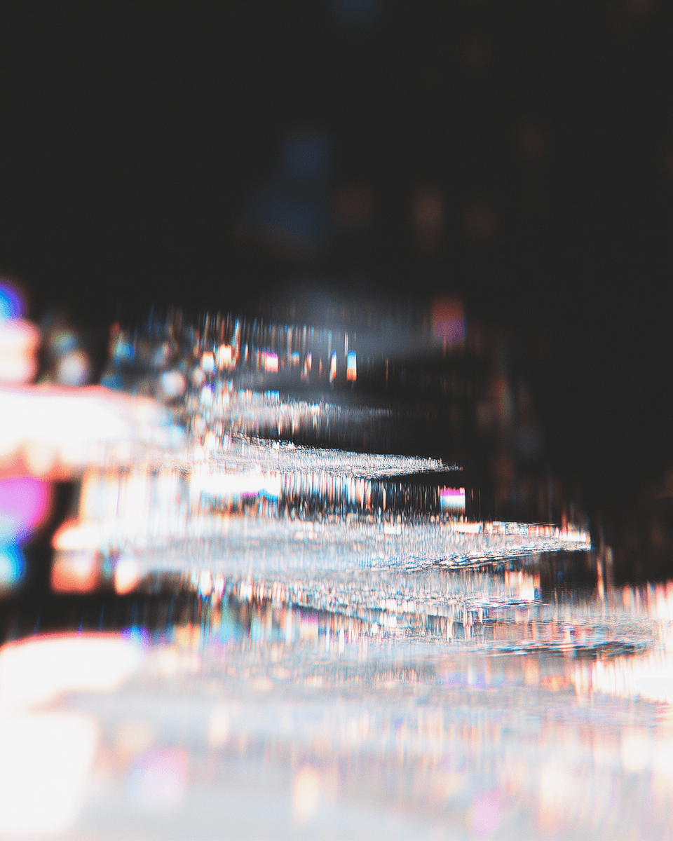 Abstract light refraction with shimmering textures and prismatic colors on a dark background, creating a dreamy, ethereal effect.