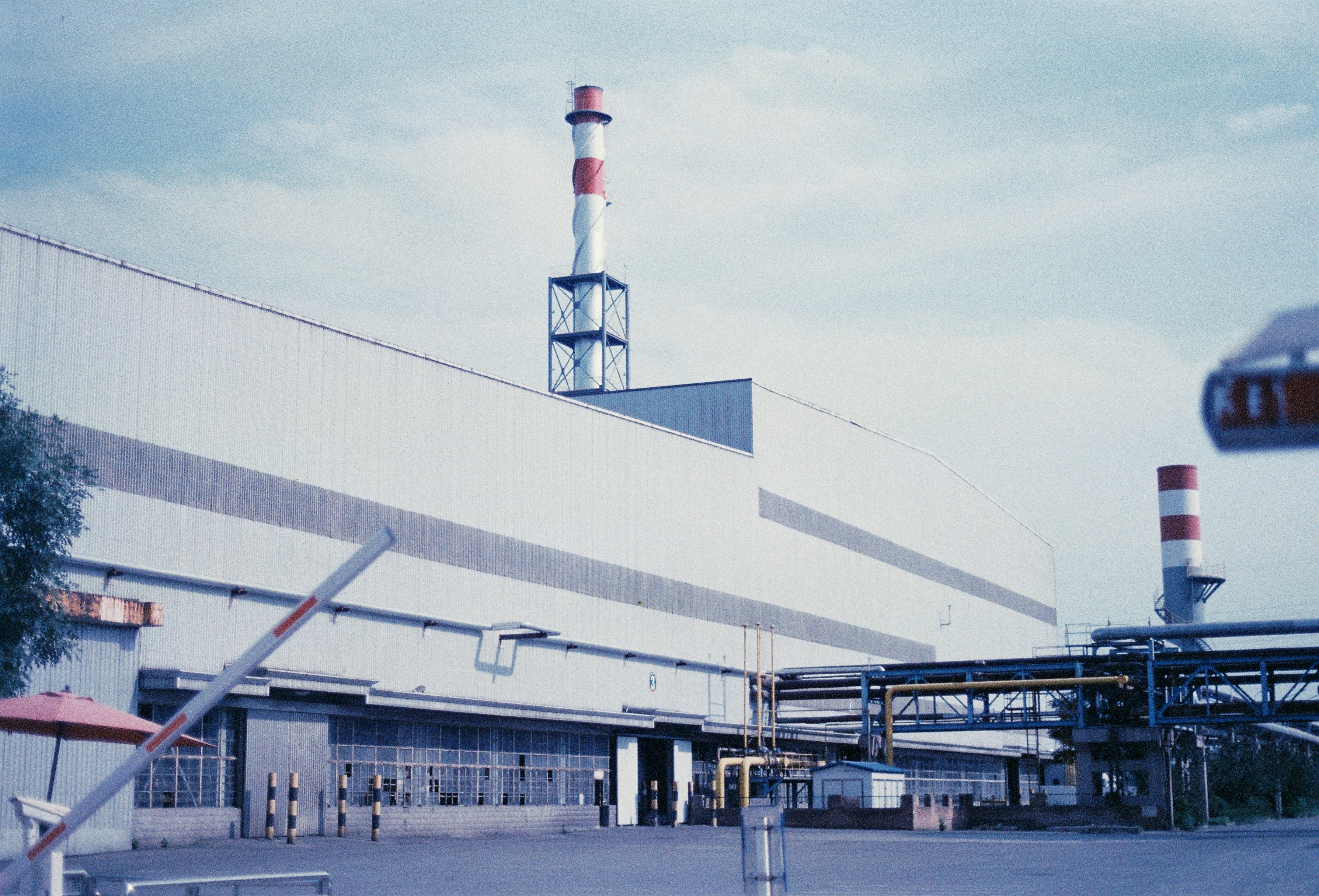 Industrial building with smokestacks under a cloudy sky