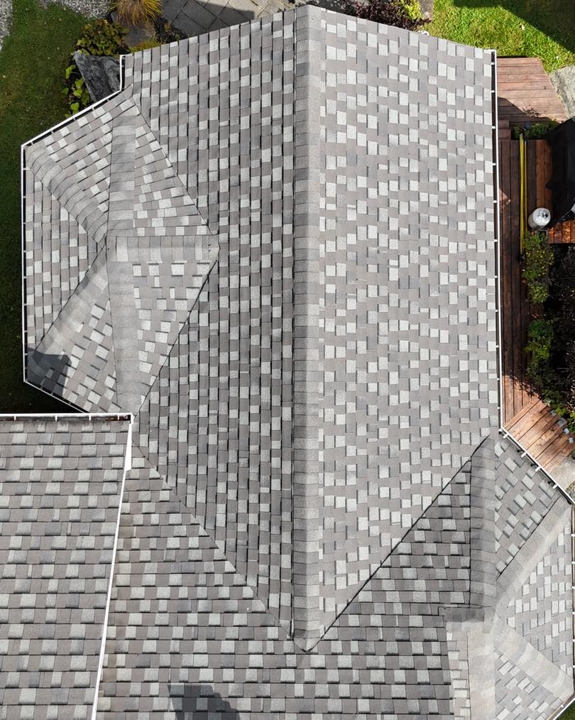 Gros plan sur la pose de bardeaux d’asphalte avec alignement précis et finition uniforme sur une toiture résidentielle