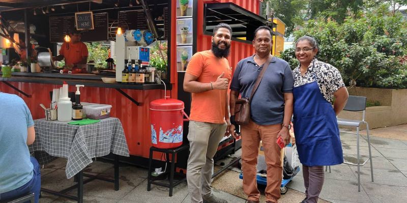Mithun and his customers posing in front of their container store in Mutiara Damansara.
