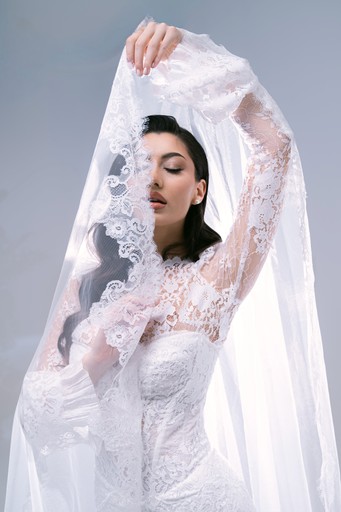 Mireasă cu voal din dantelă ridicat elegant, pe fundal alb minimalist — fotografie nuntă artistică București