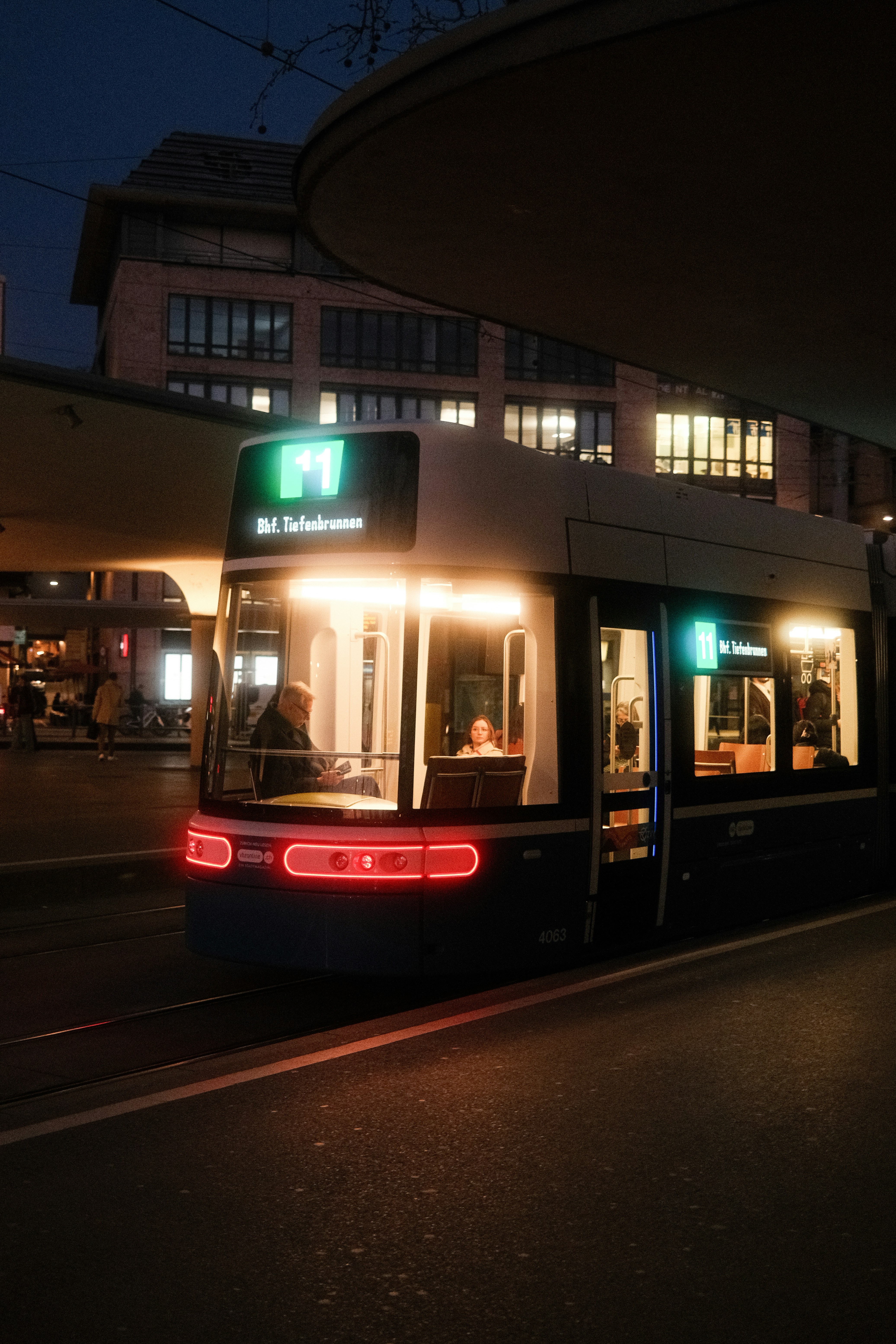 A tram at night with illuminated windows and lights.