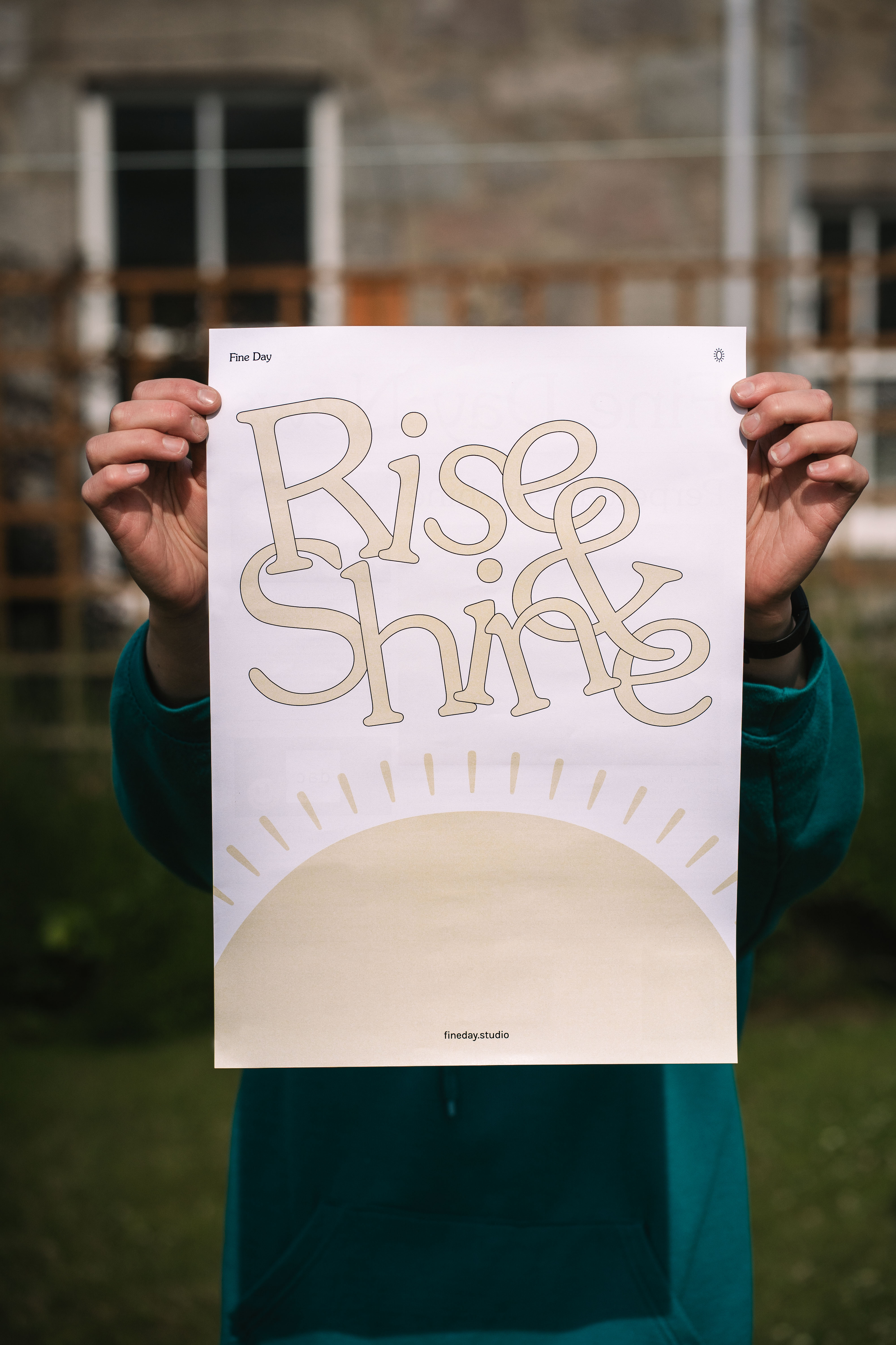 a person holding up a poster that says "Rise & Shine"