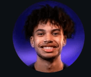Woman in sunglasses poses against vibrant red background, wearing a beige blazer and black top. Sunlight casts dynamic shadows, creating a stylish, confident mood.