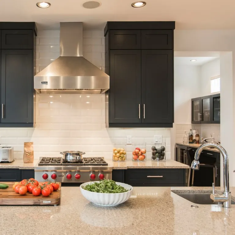 Image of Luxury kitchen design with dark cabinets, stainless steel appliances, and elegant layout by KHD Homes.