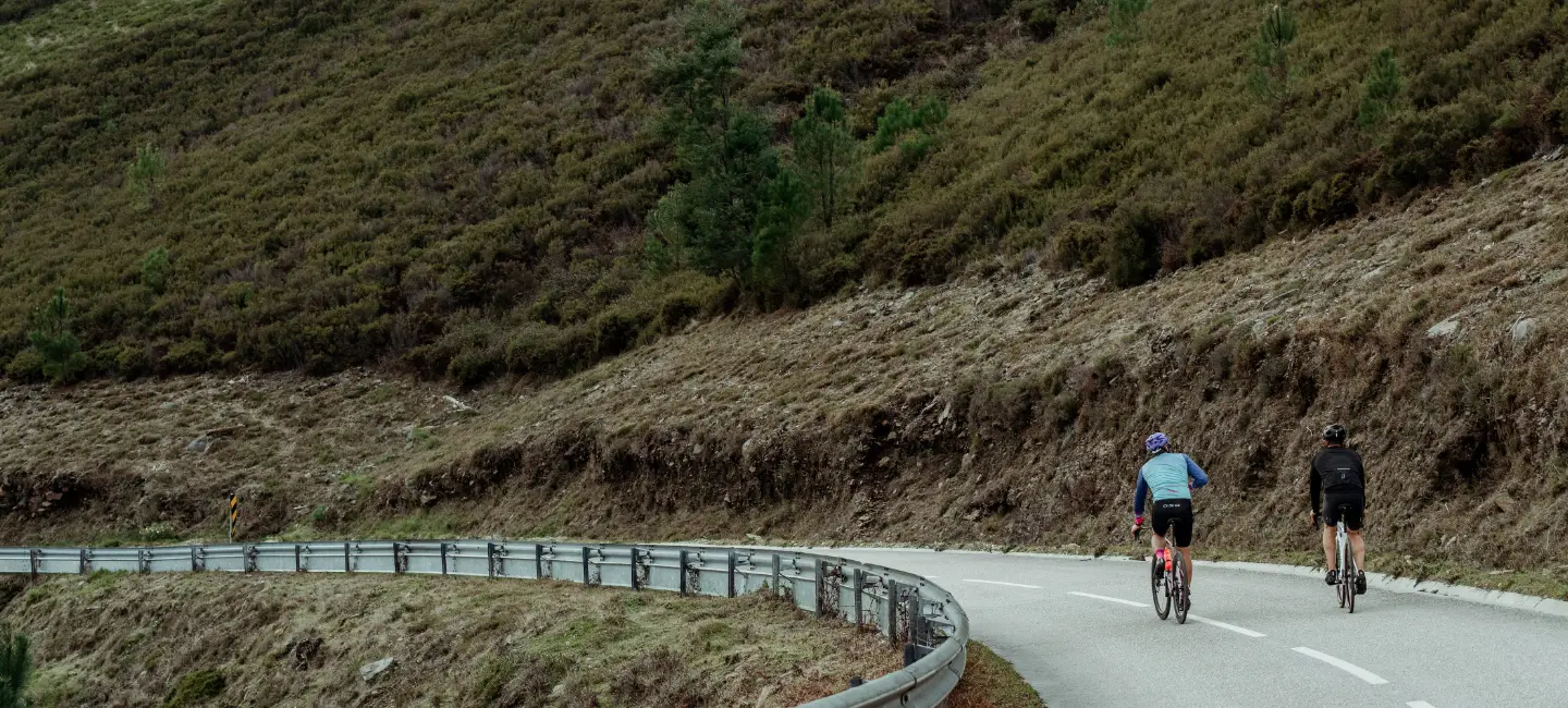 two people riding their bike on a road