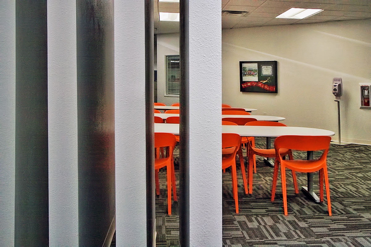 Close-up detail shot of the office space with a table and chairs in the distance, emphasizing the modern design.