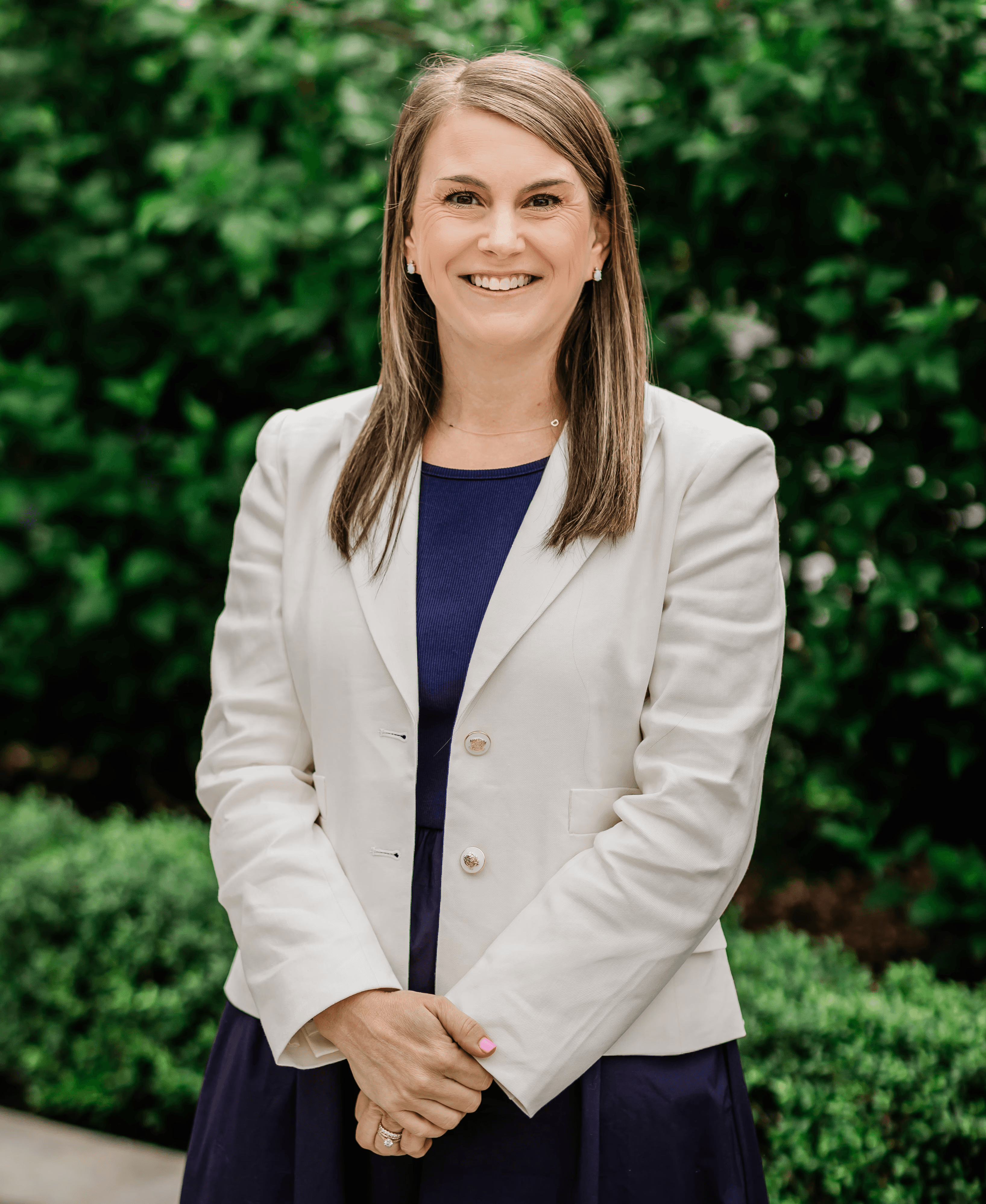 A woman in a business suit standing with her arms crossed