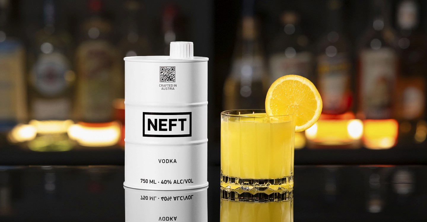 A NEFT Barrel and a glass of Screwdriver on a bar counter.