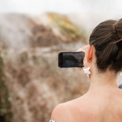 游客拍摄火山口照片。