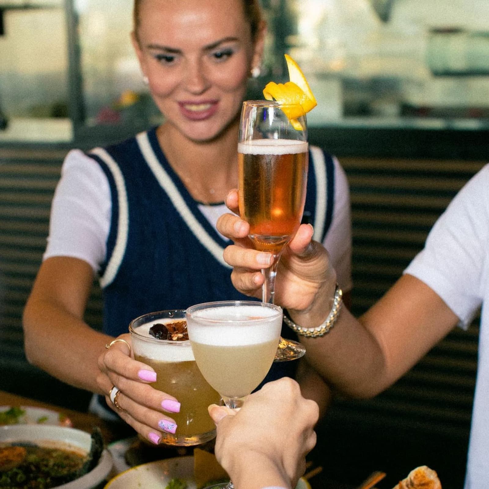 Happy hour Dubai scene with friends clinking glasses and enjoying drinks at the bar.