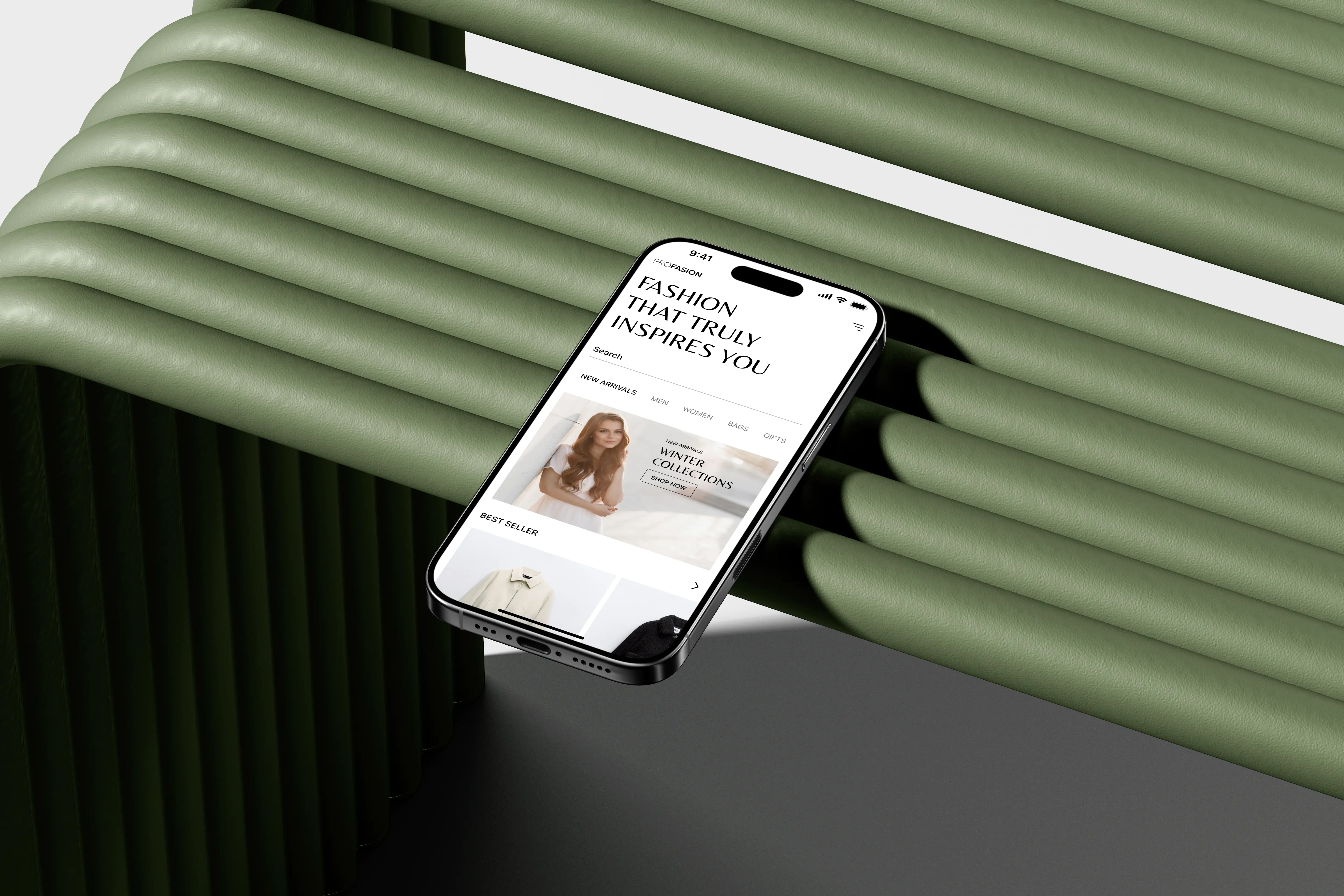 iPhone displaying a fashion e-commerce app UI placed on green sculptural props, illustrating modern mobile interface design