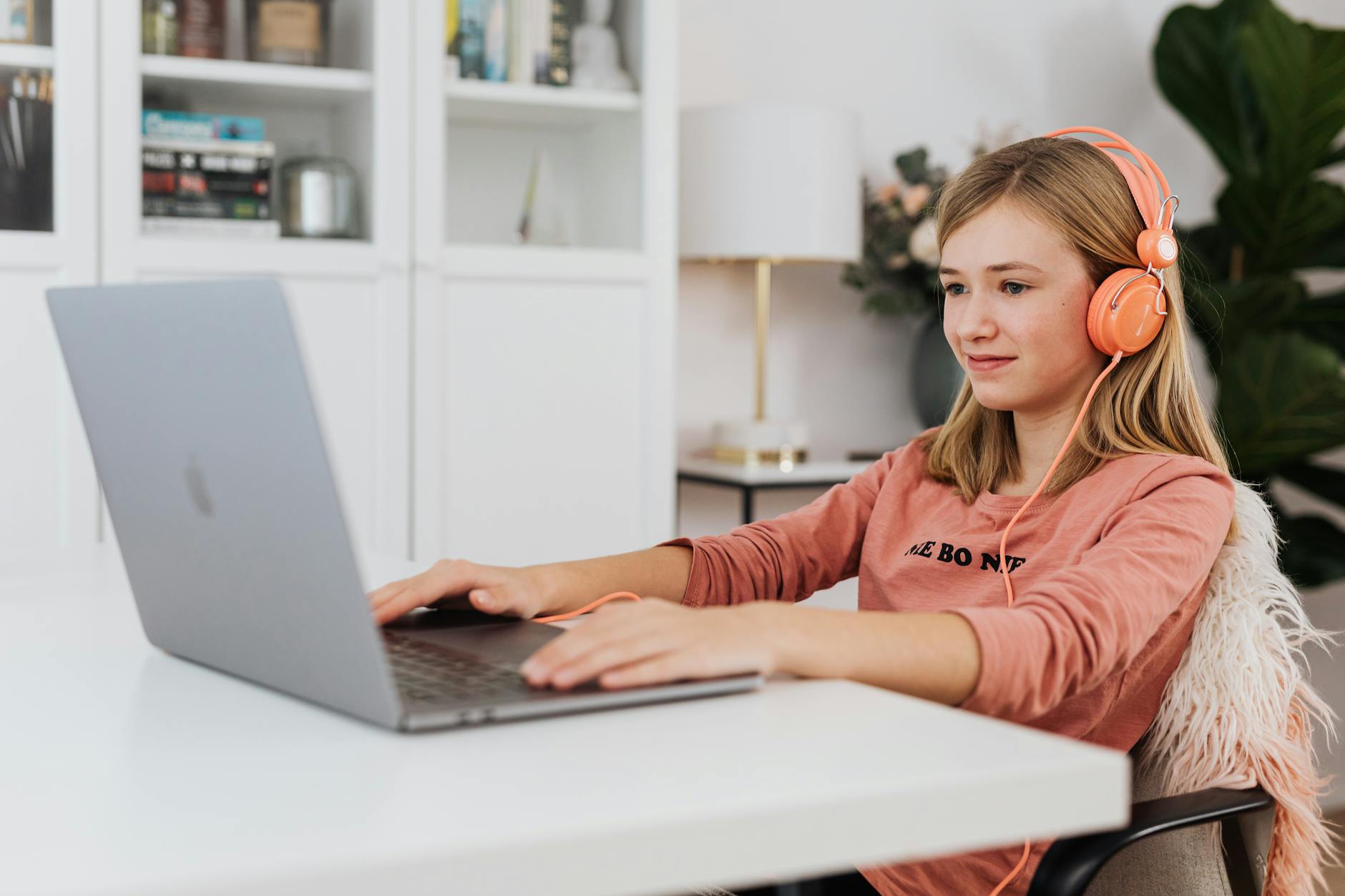 Close-up of a laptop screen displaying student websites for essay outlining next to a focused teenager.