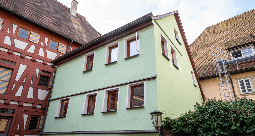 Das Bild der Akademie, eingebettet zwischen roten Backsteinbauten, zeigt eine charmante Architektur in einer malerischen Umge