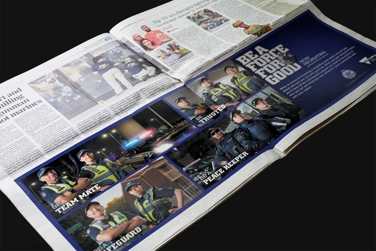 Newspaper spread with a Victoria Police recruitment ad, 'Be a force for good', showing officers as team mate and peace keeper
