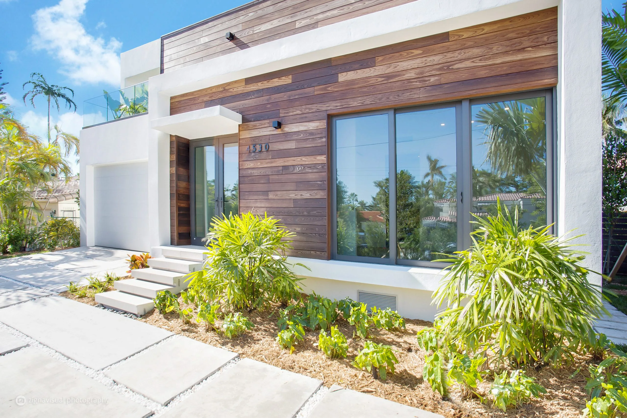 Front entrance of modern residential home with wood cladding facade on Alton Road Miami Beach