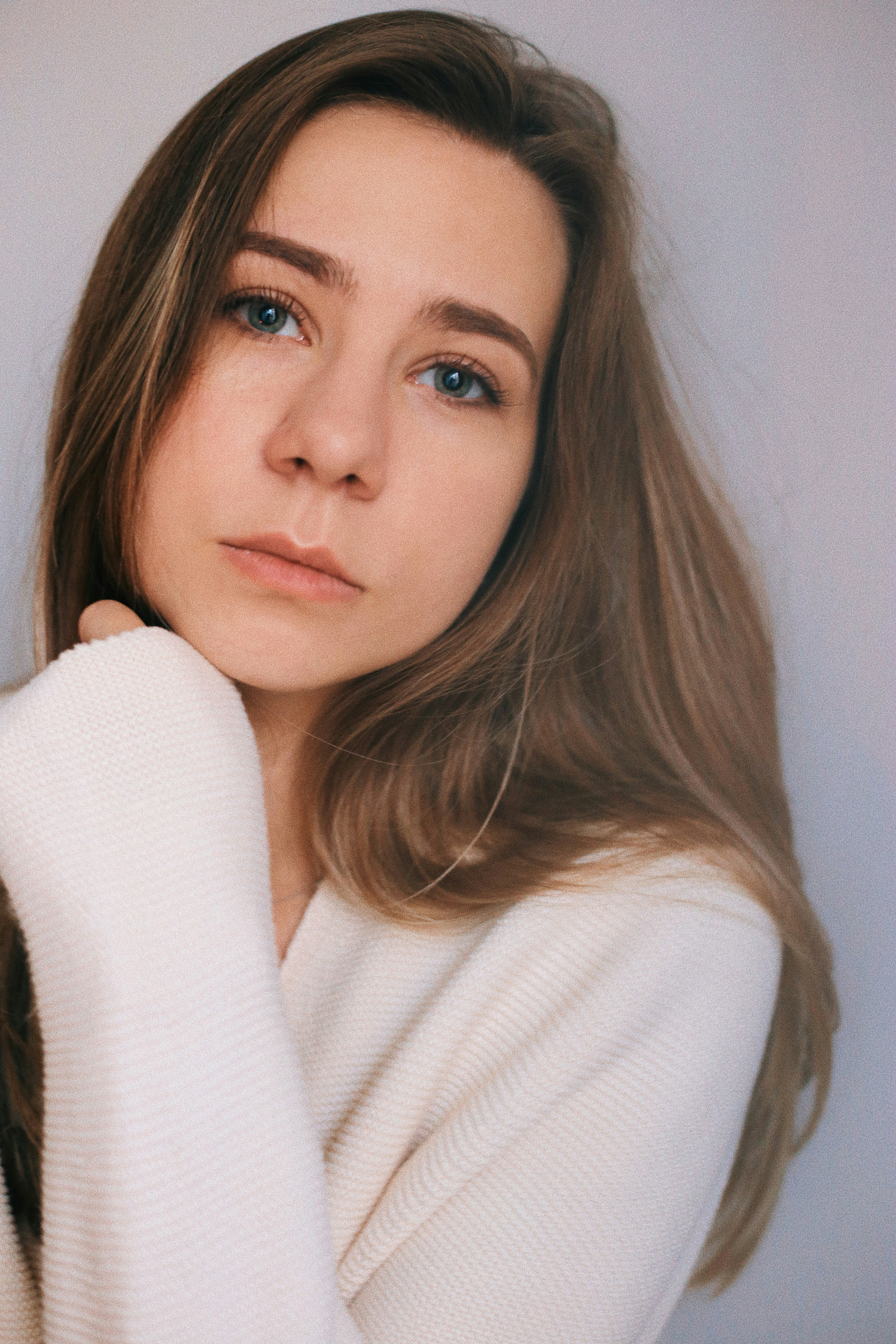 a woman in a white sweater posing for a picture