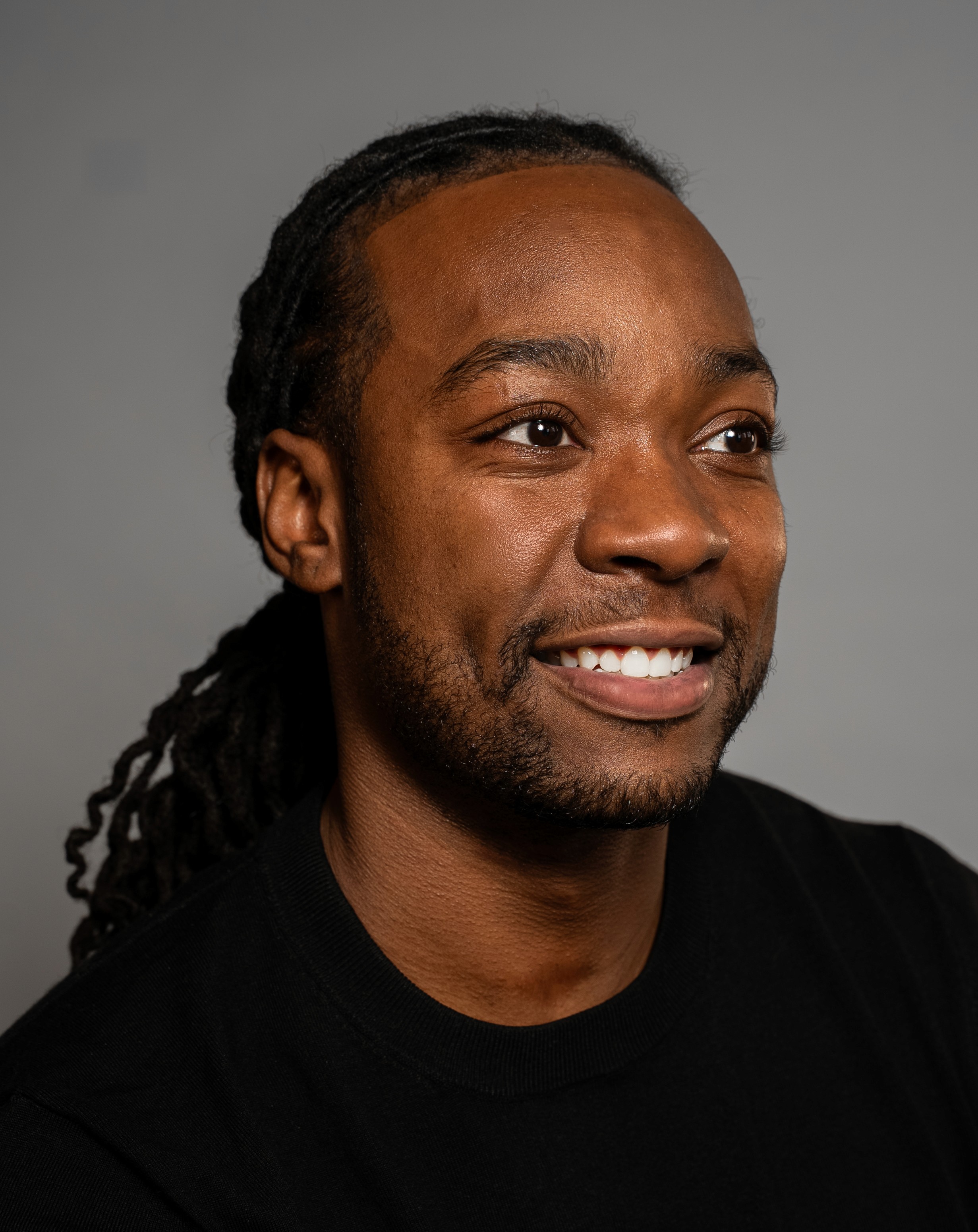person in gray hoodie holding red and white box
