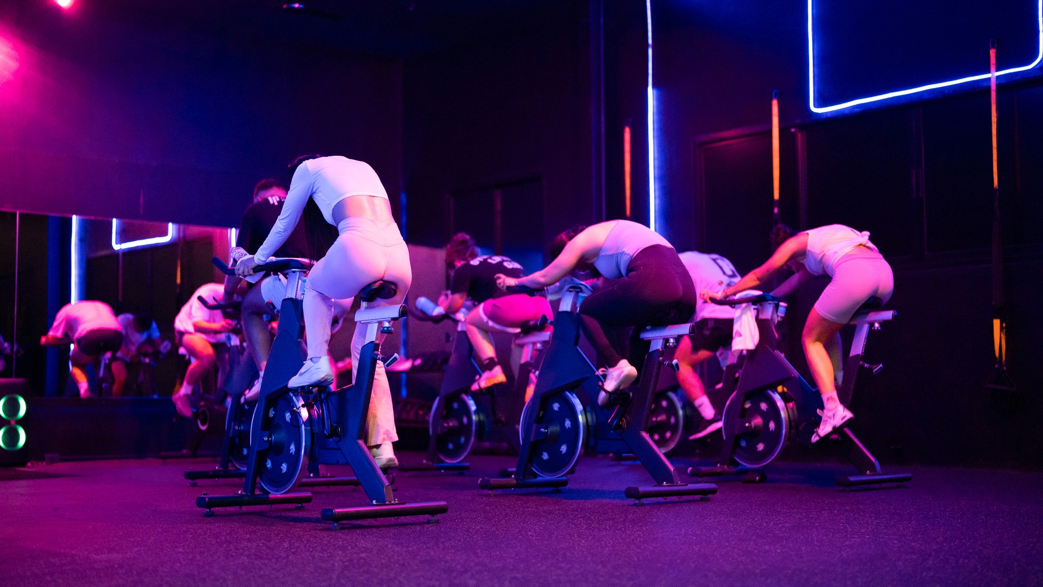 Intense spin cycling class at Legacy Muscle Universe Koh Samui, featuring immersive music and lighting in a motivating group studio.