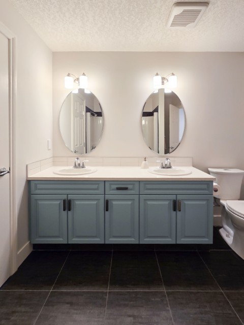 Image of Double vanity with gray cabinets and white countertops in a KHD Homes designed primary ensuite bathroom.