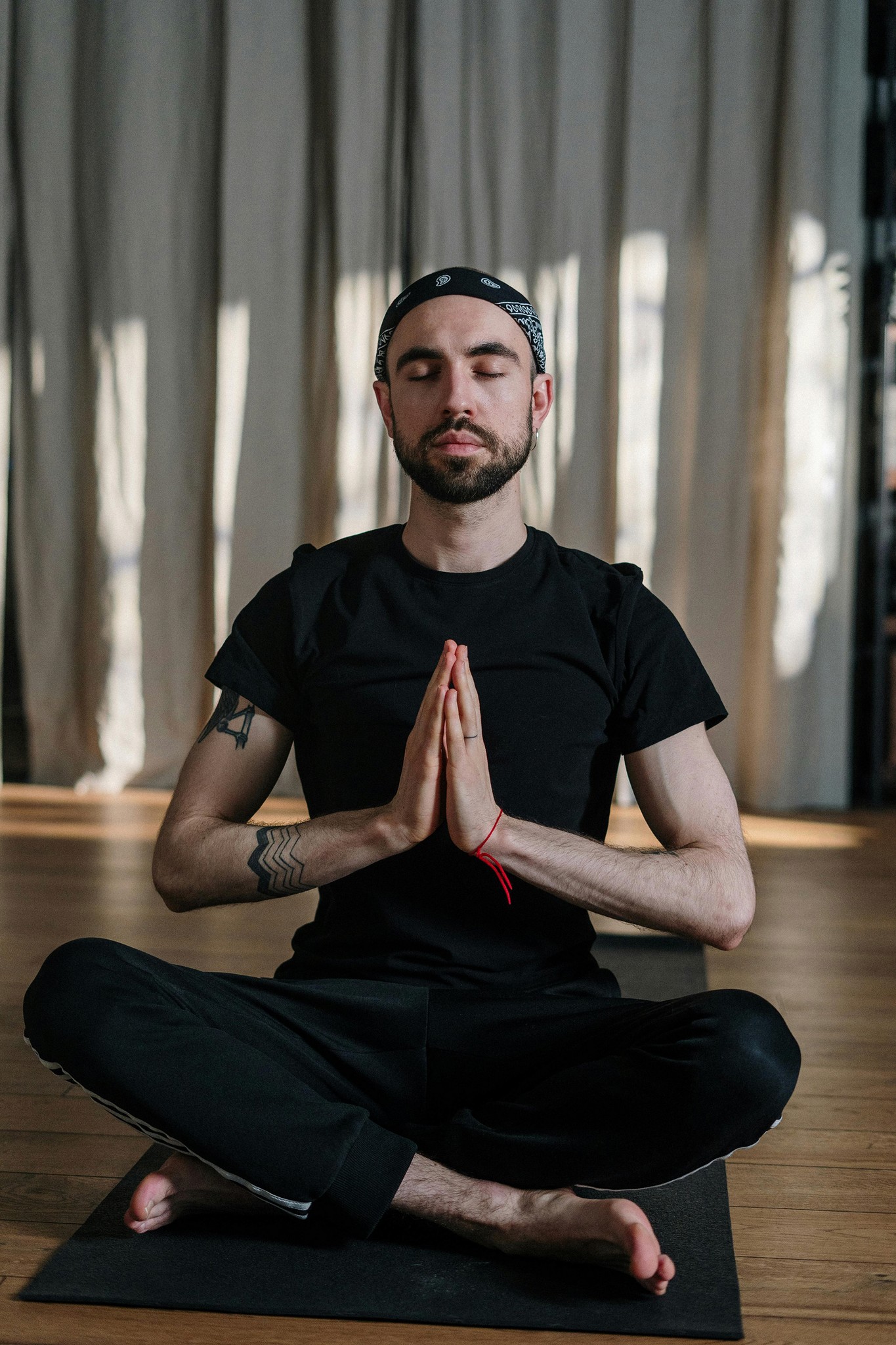 Man meditating in seated yoga pose with eyes closed