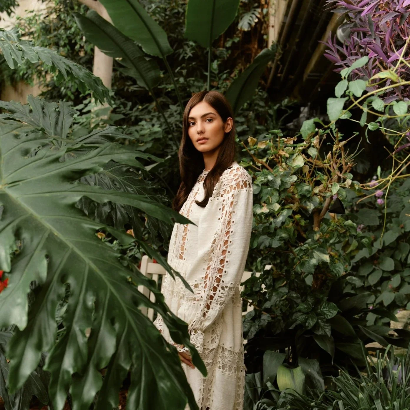 Woman in forest of green plants looking at the camera