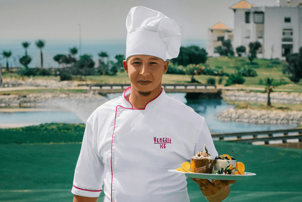 woman in white chef uniform holding green plate with food