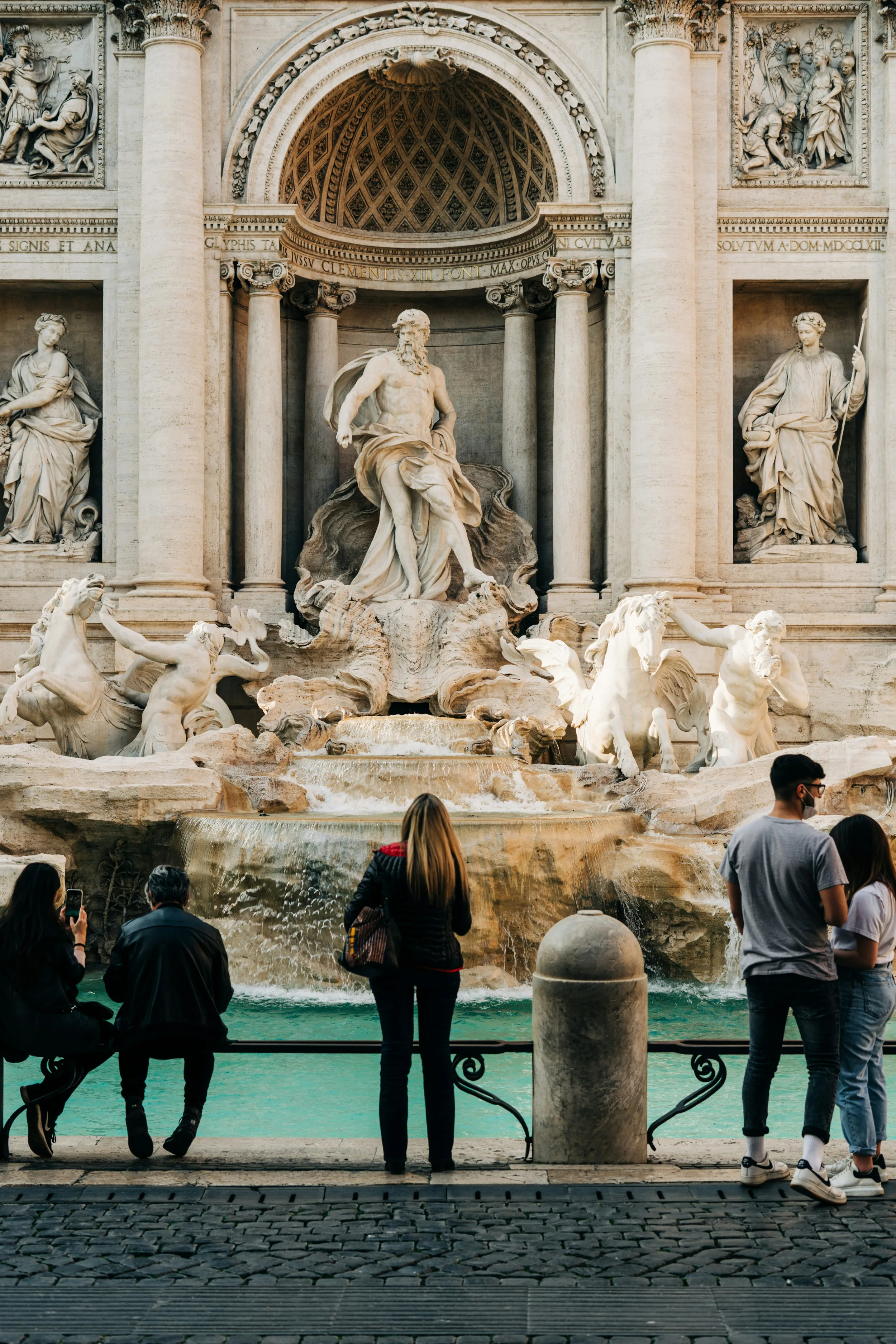 A woman gazes up at one of the statues at the Trevi Fountain in Rome.