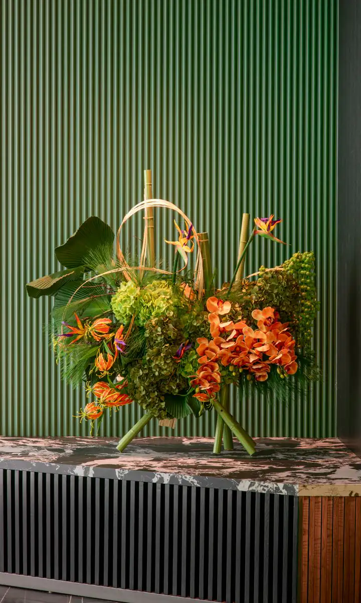 Floral arrangement in front of an emerald fluted wall