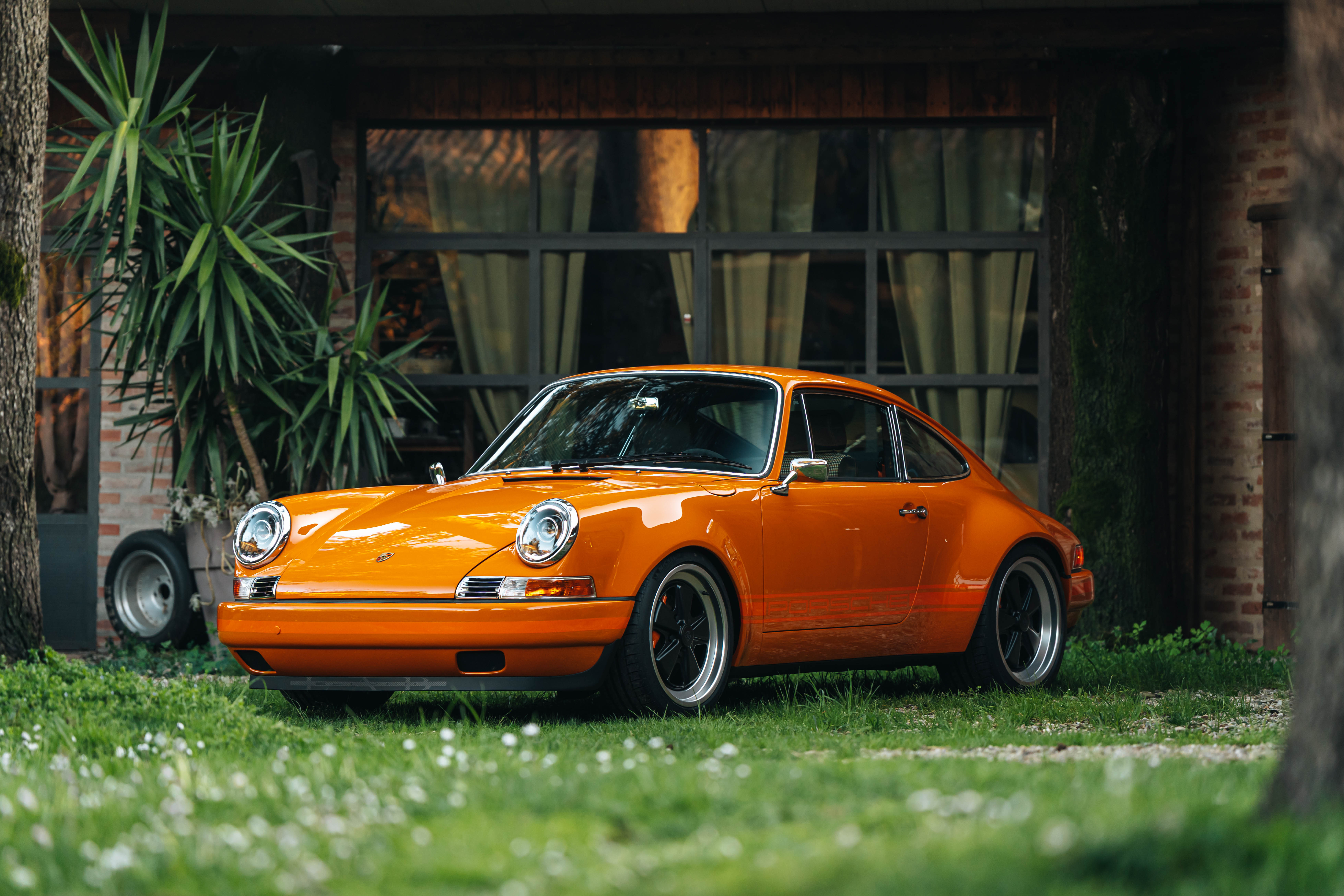 Foto 3/4 frontale di Porsche Carrera con carrozzeria arancione