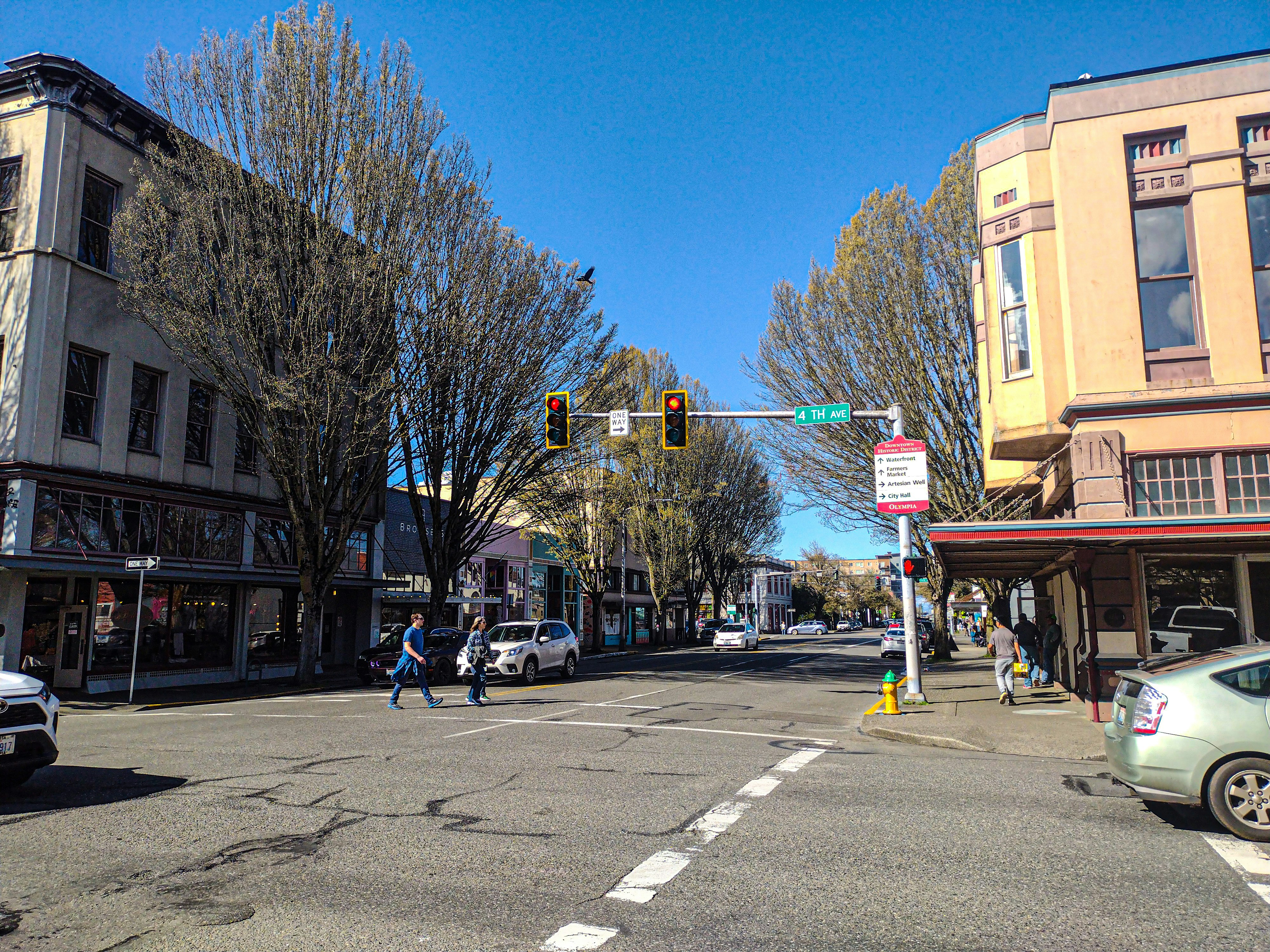 a couple of people crossing a street at a traffic light