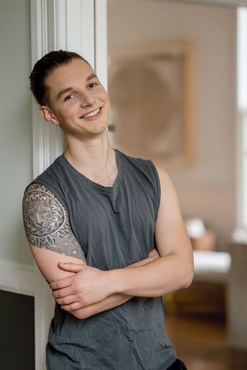 Smiling person seated indoors — founder of Seven Life Areas, offering guidance for living with clarity, harmony, and purpose.