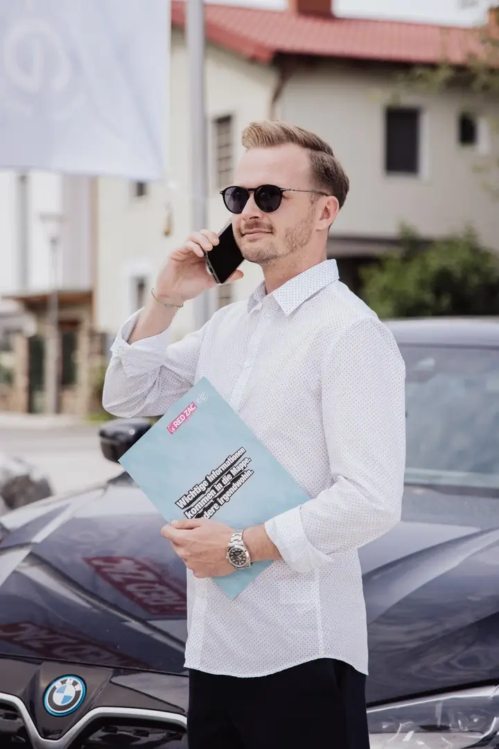 Professionelle Gastronomie- & Interieur-Fotografie: Gemütliche Lounge-Ecke mit rotem Sessel und beleuchteter Wein-Präsentation, inszeniert mit warmem Ambient-Licht und Fokus auf Design-Details.