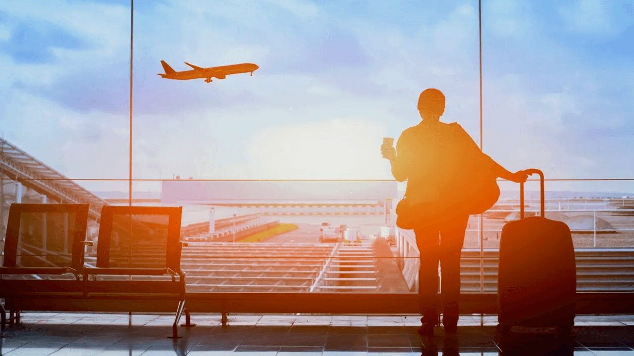 Happy traveler waiting for a flight in an airport departure terminal