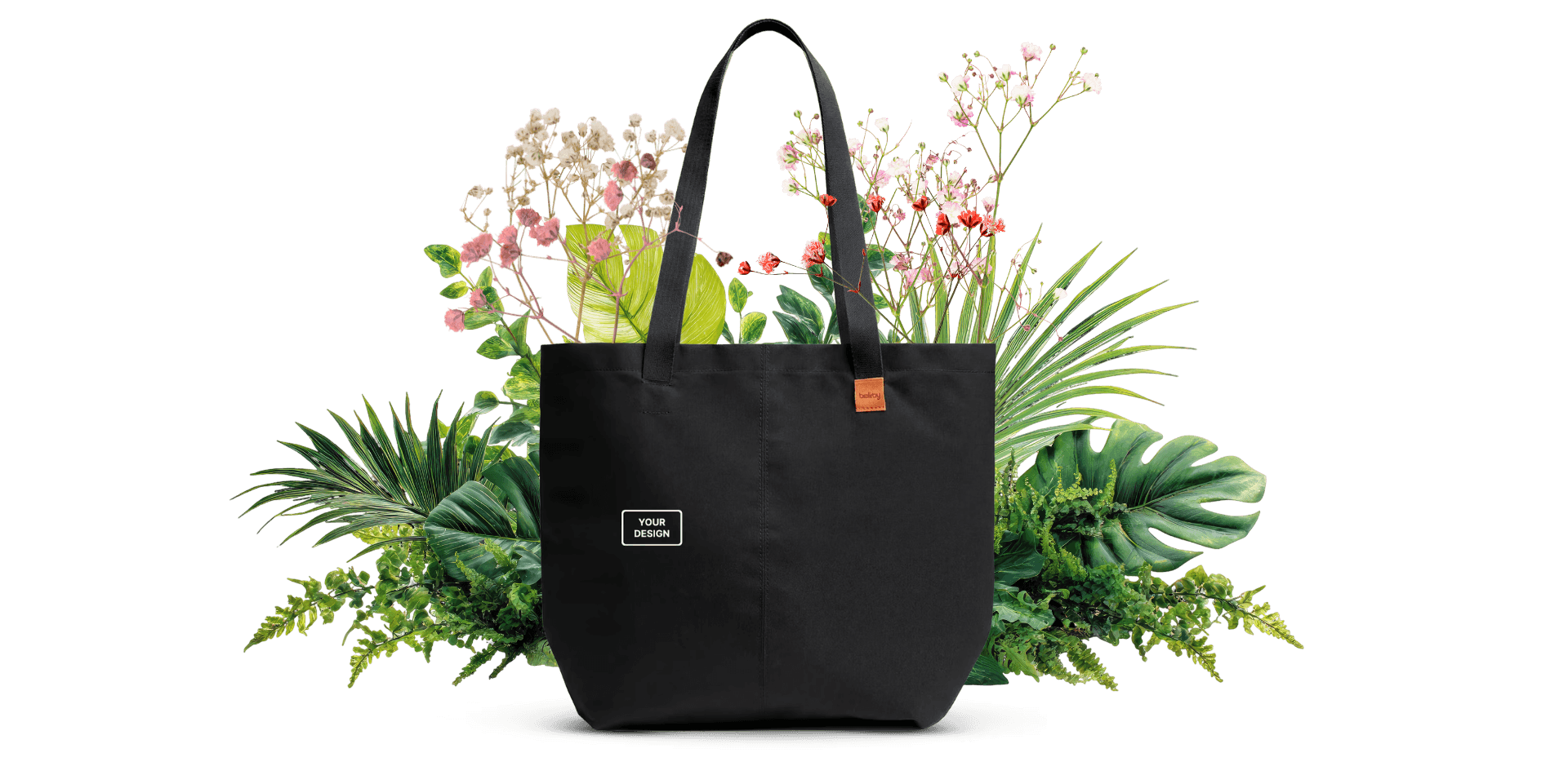 Custom branded black tote bag with floral and greenery backdrop for corporate gifting