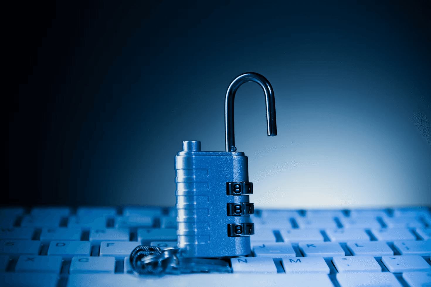 Open combination padlock resting on a computer keyboard, representing software security