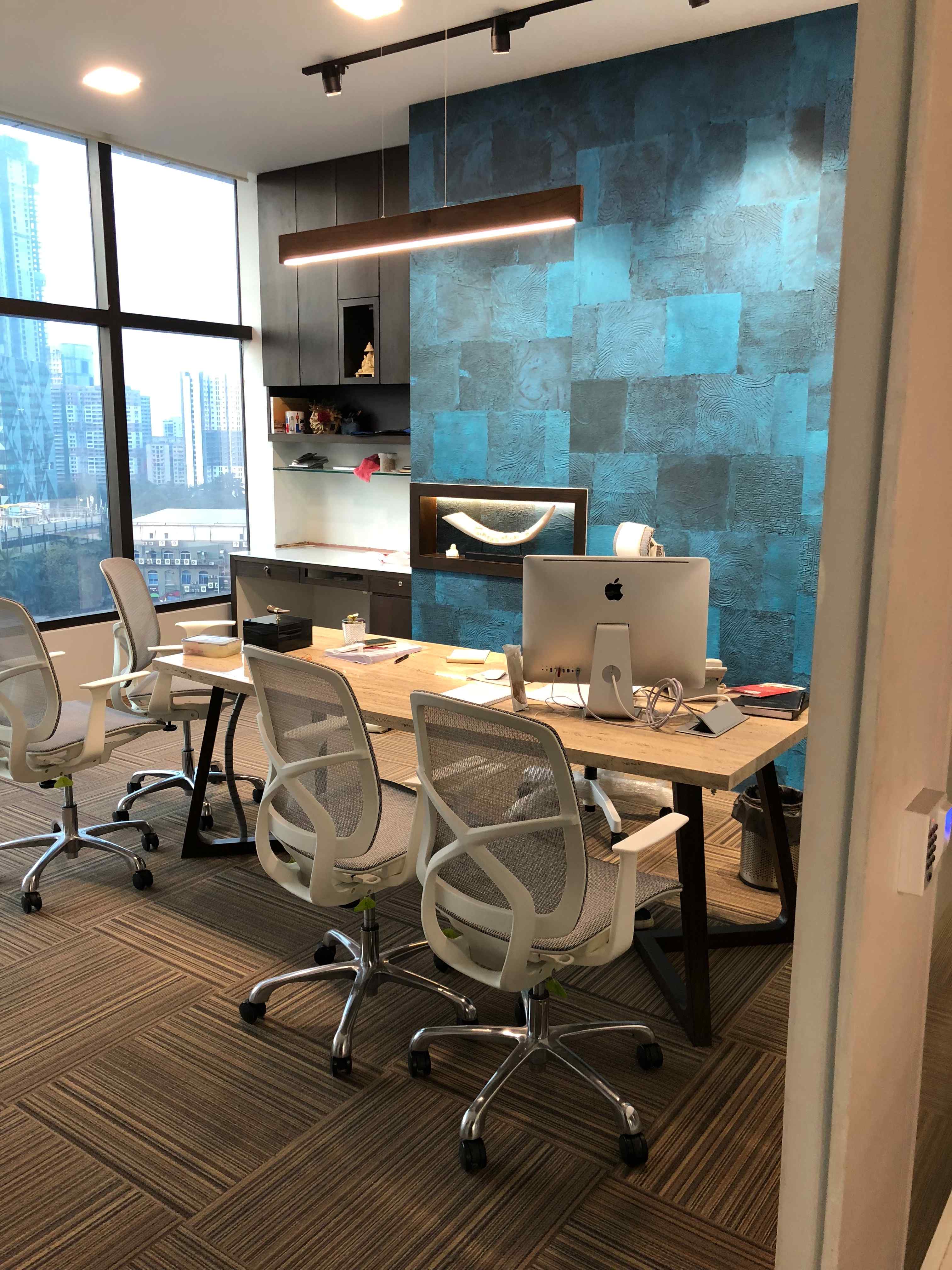 Nature-inspired preschool entrance with sculptural tree partitions and suspended green leaf ceiling panels.