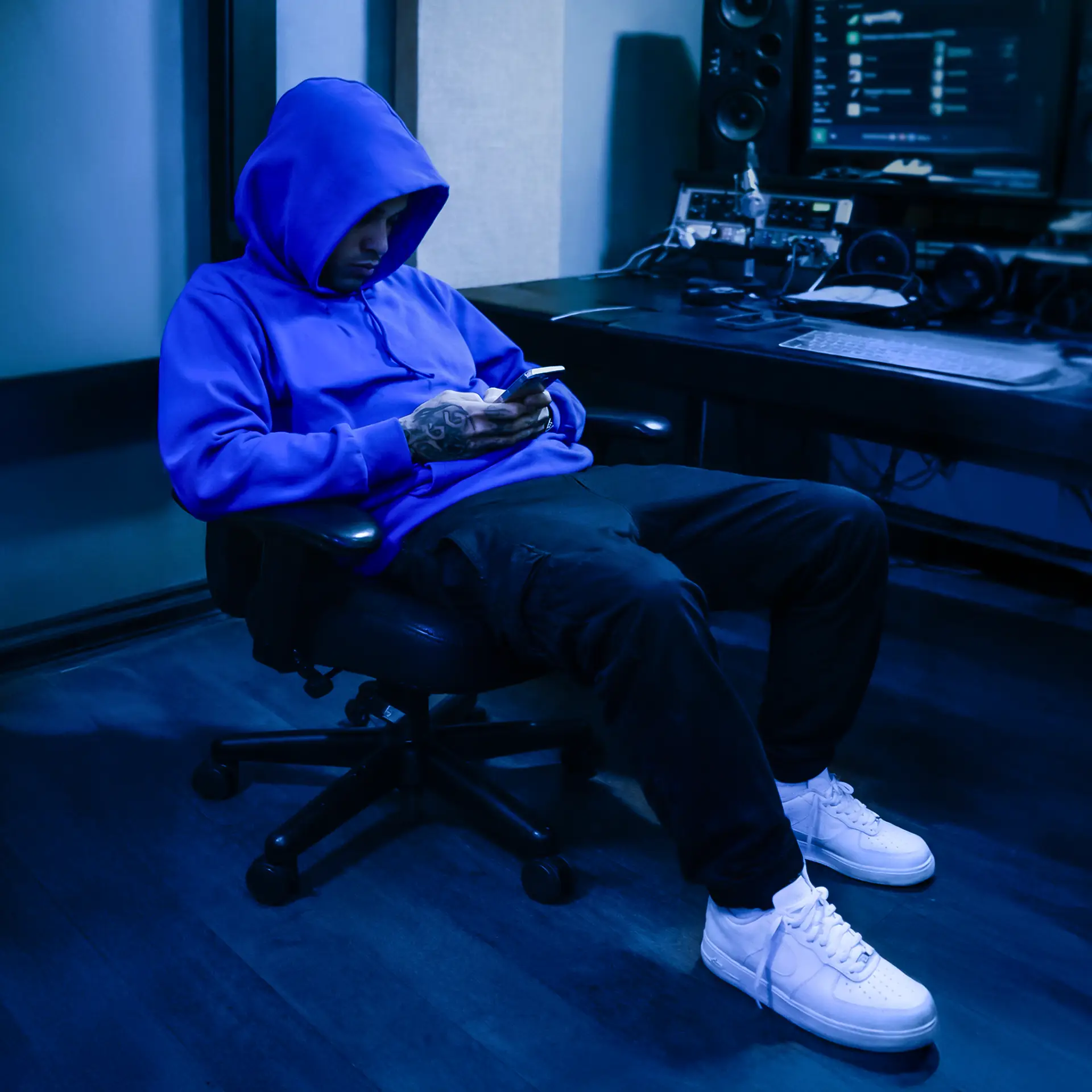 Artista emergente in studio di registrazione controlla gli ascolti sul telefono