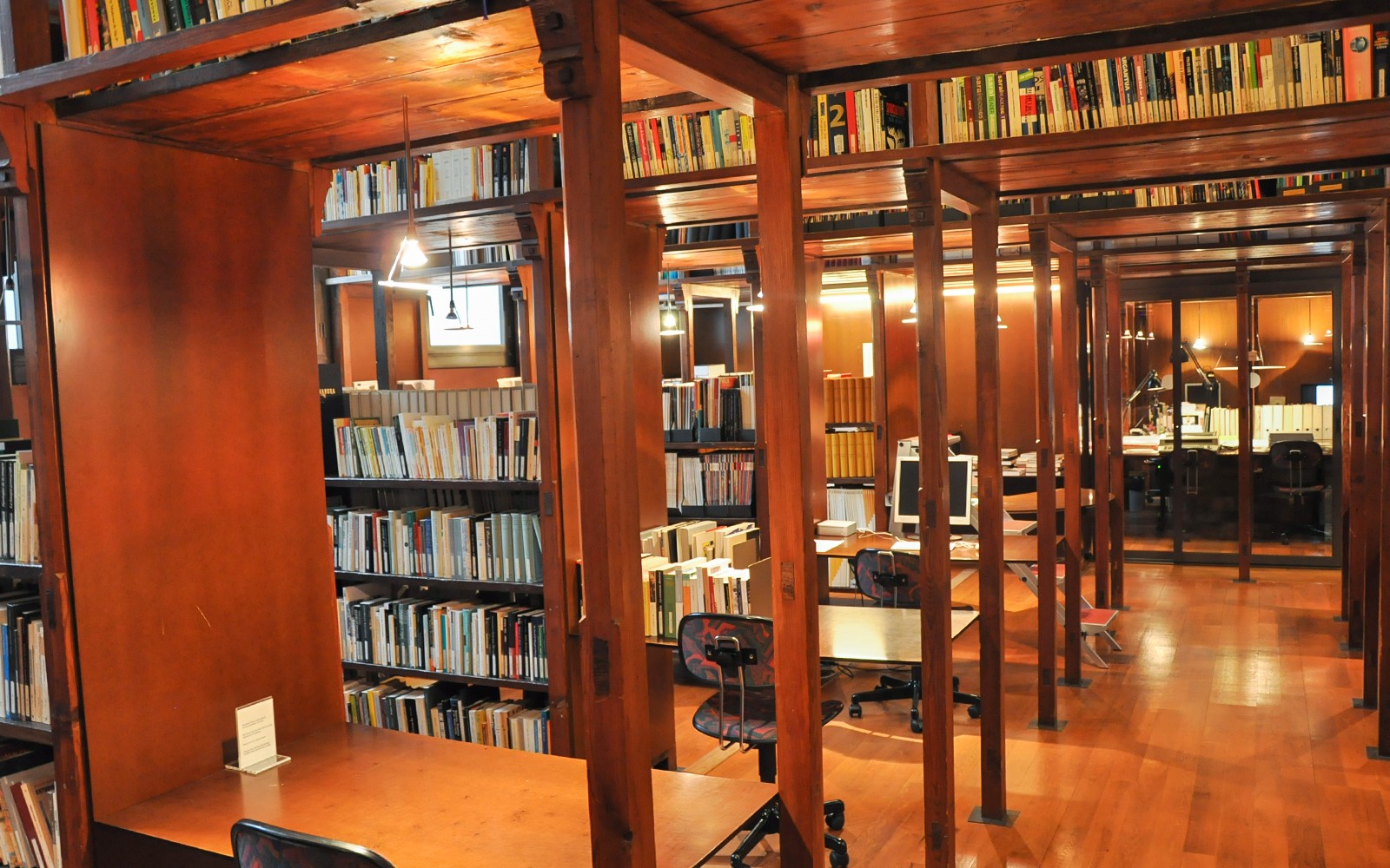 Biblioteksinteriör på Fundació Antoni Tàpies i Barcelona, med trähyllor och läsplatser.