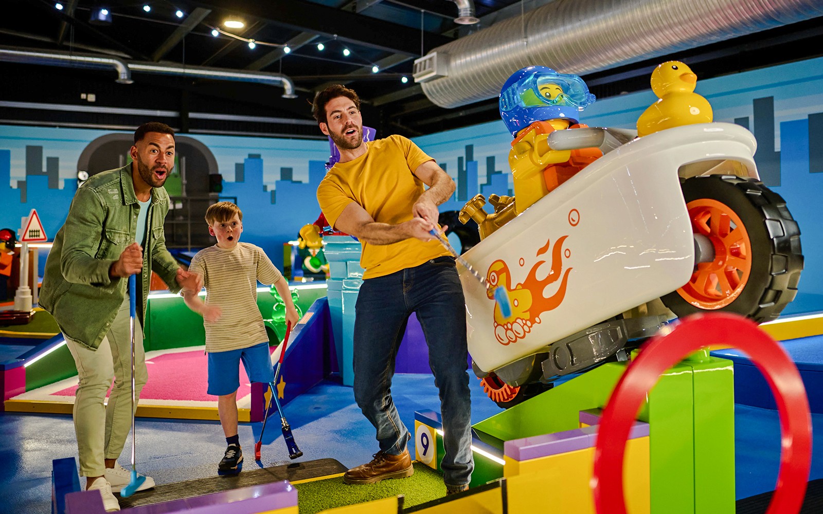 Group playing mini-golf at LEGOLAND® Adventure Golf with colorful LEGO obstacles.