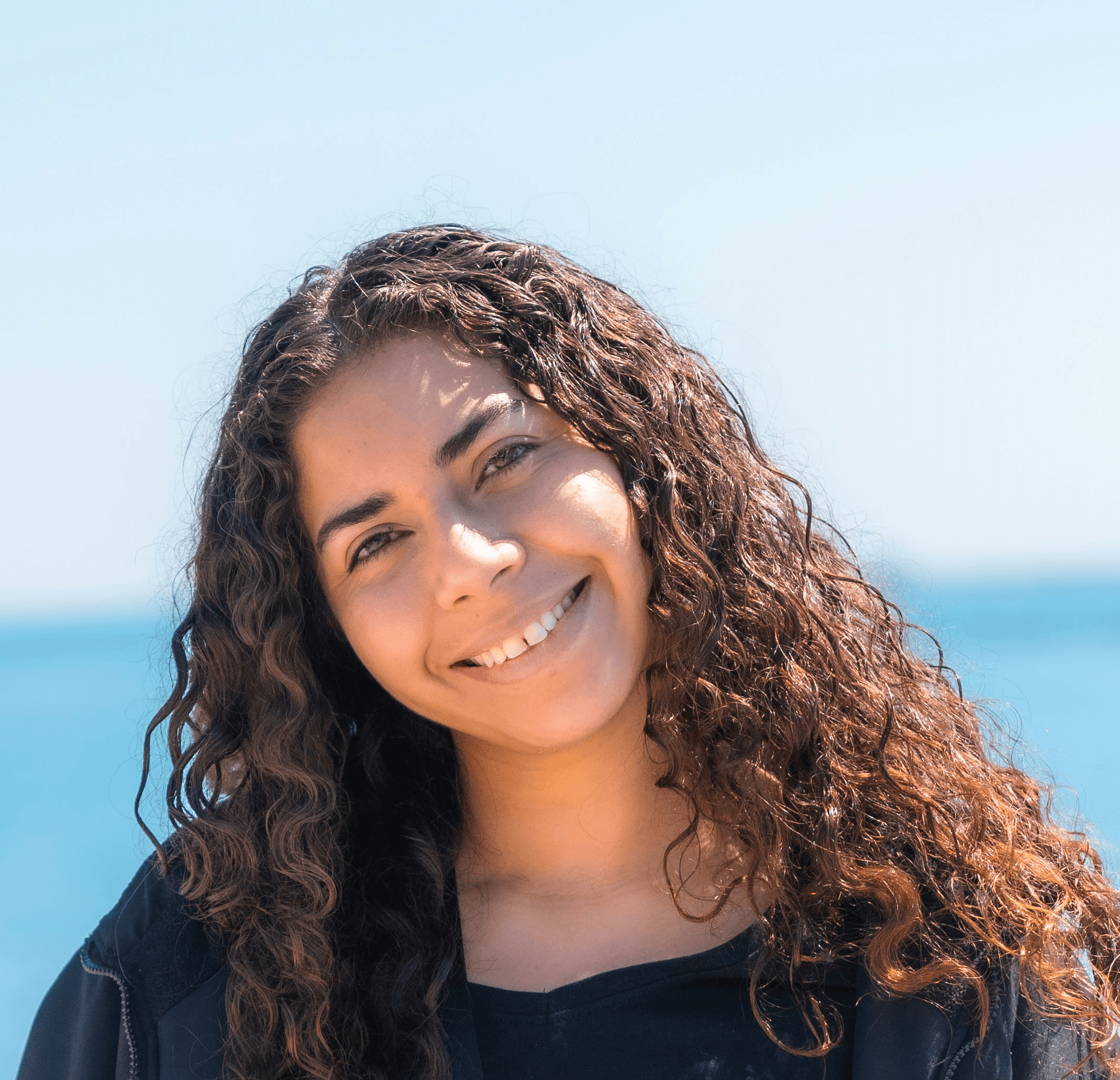 a woman standing on a pier next to the ocean