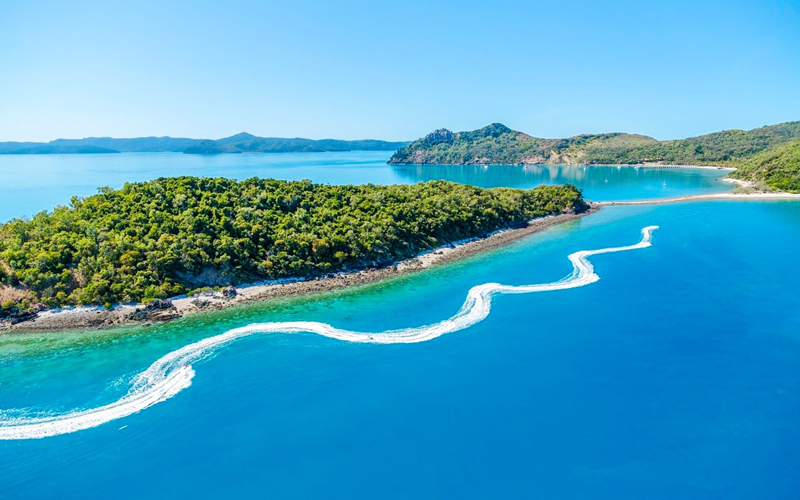 תצפית אווירית על שבילי אופנועי ים ליד אי ירוק בוויטסאנדיס, אוסטרליה.