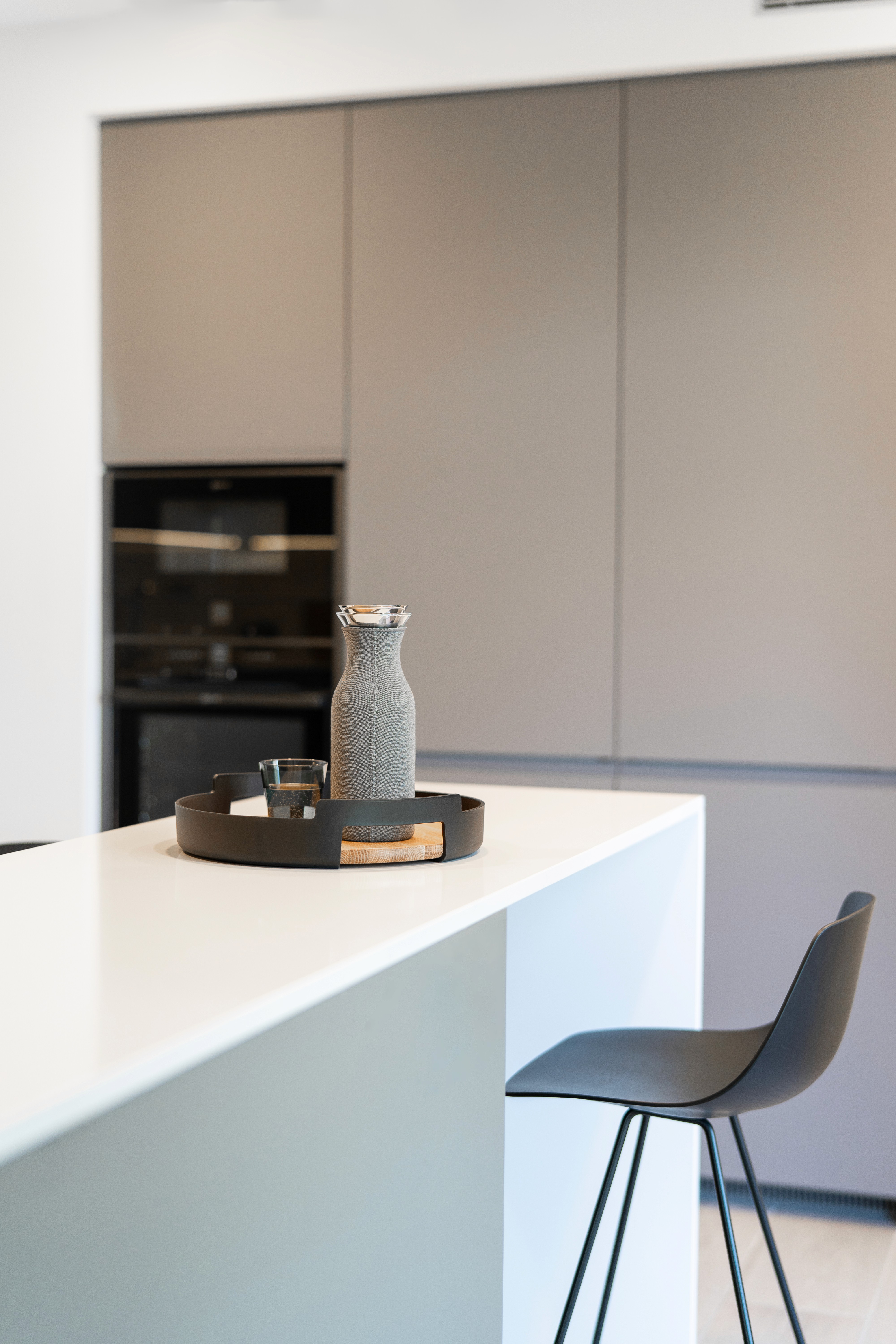 Detalle cocina con muebles gris oscuro y encimera blanca