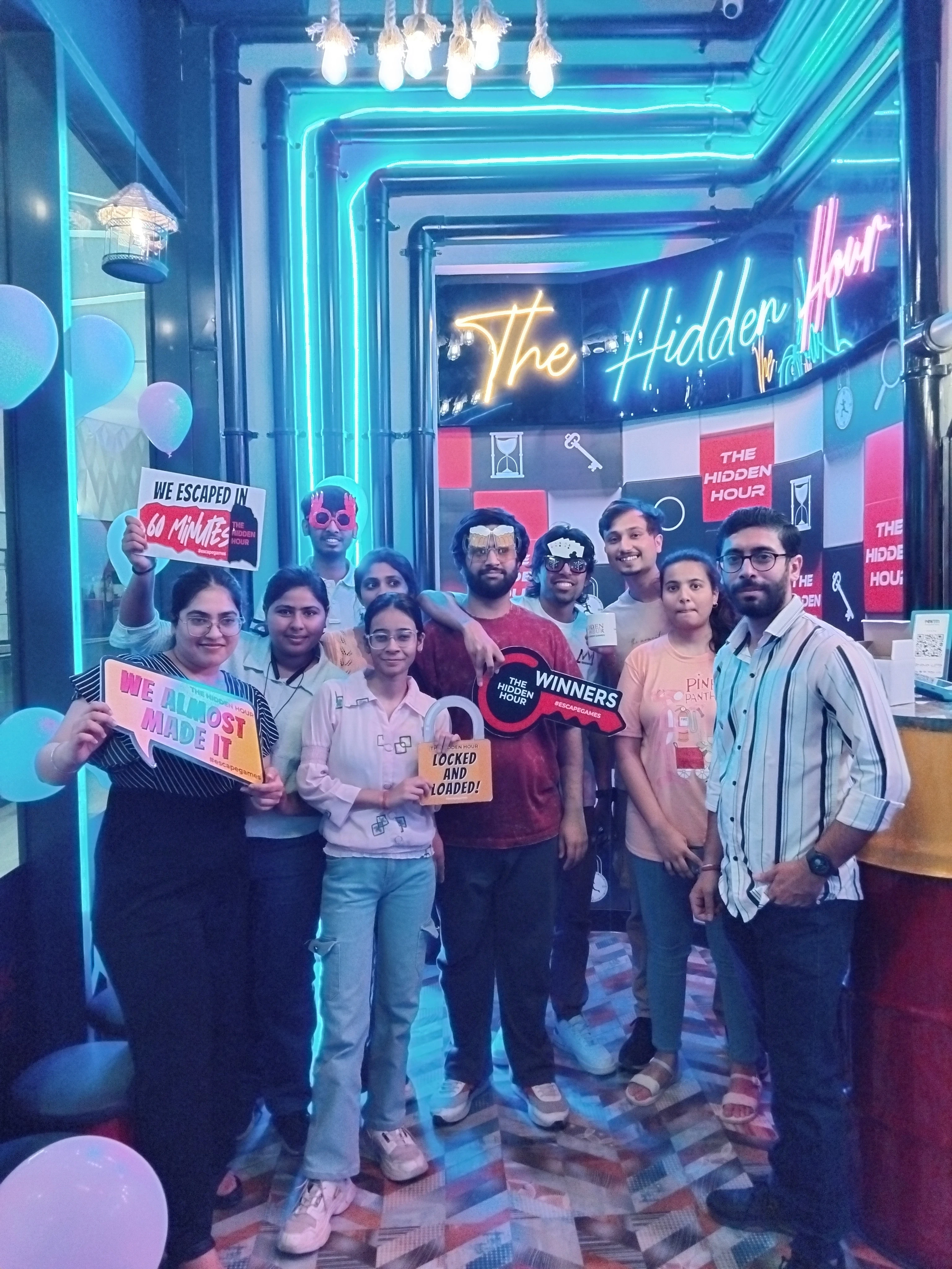 Teammates posing with props affter playing thrilling escape games at The Hidden Hour centre