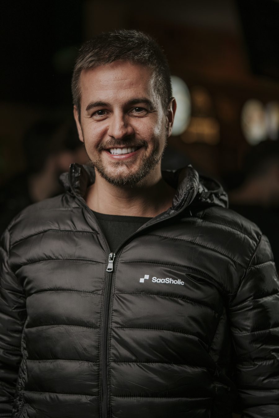 Felipe Spina sorrindo, retrato com luz quente ao fundo