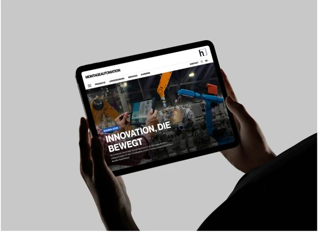 Person hält Tablet mit geöffneter Website der Höhenbach AG, die industrielle Automationslösungen und Robotertechnik präsentiert.