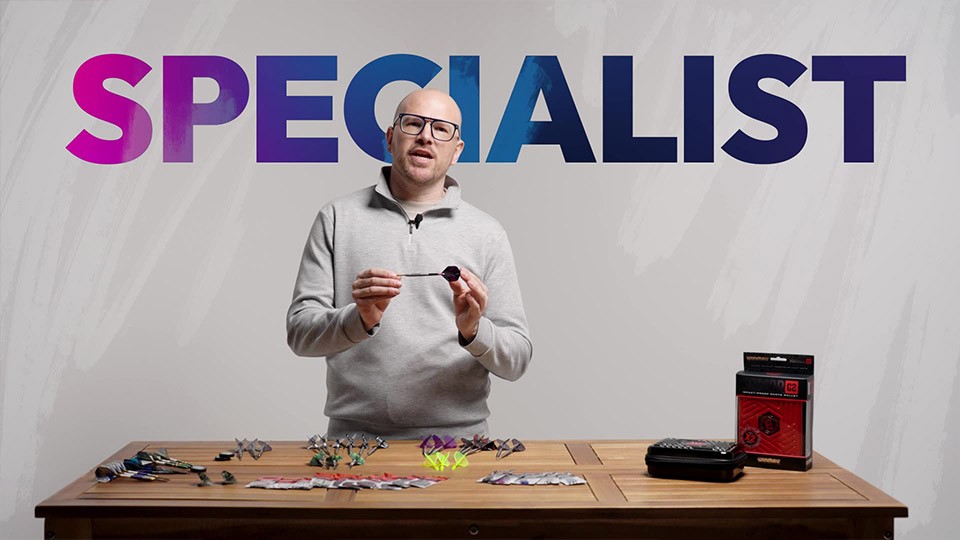 A man holding a dart with the word Specialist behind him