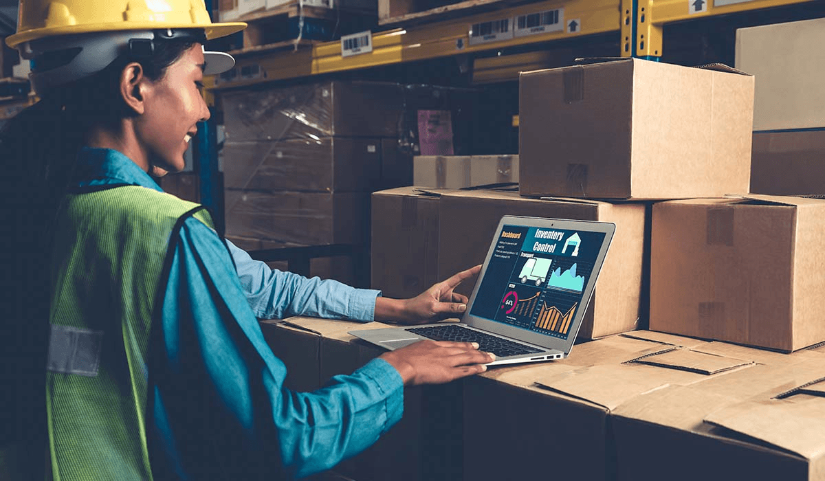 Operadores em um galpão logístico utilizando um notebook