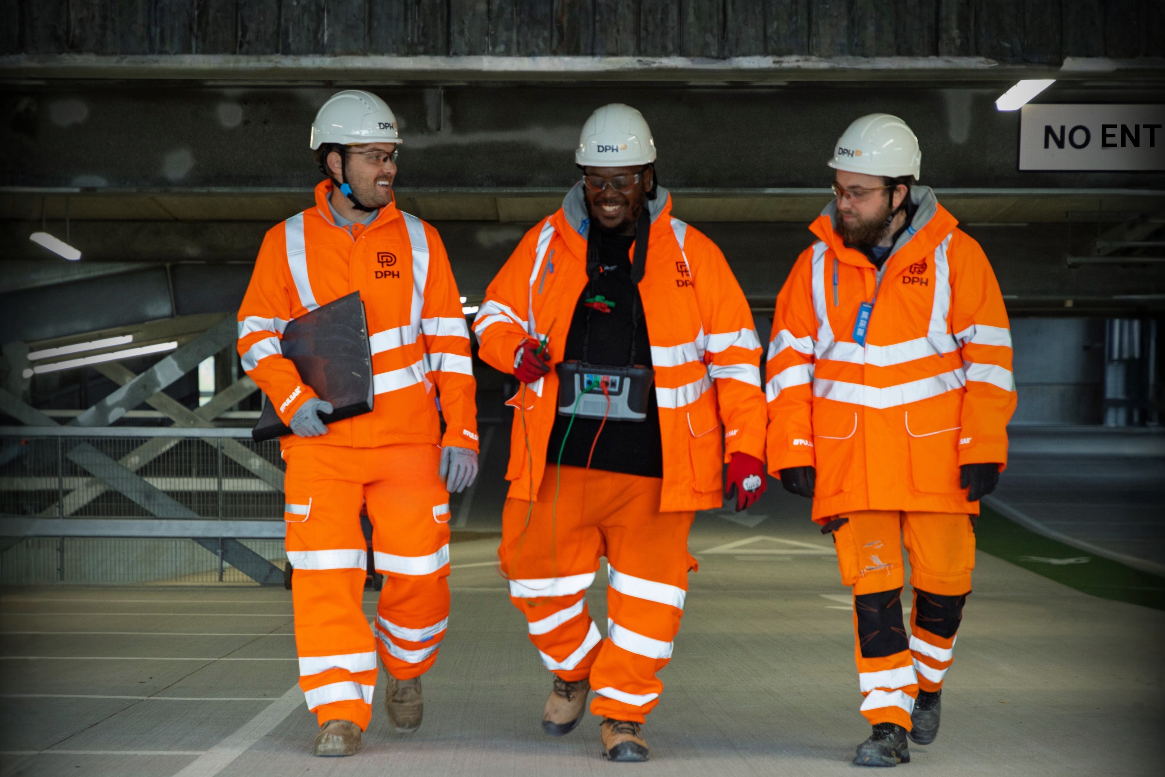 Modern building with a sleek glass facade and illuminated orange lighting, reflecting on a polished surface, creating a futuristic and elegant atmosphere