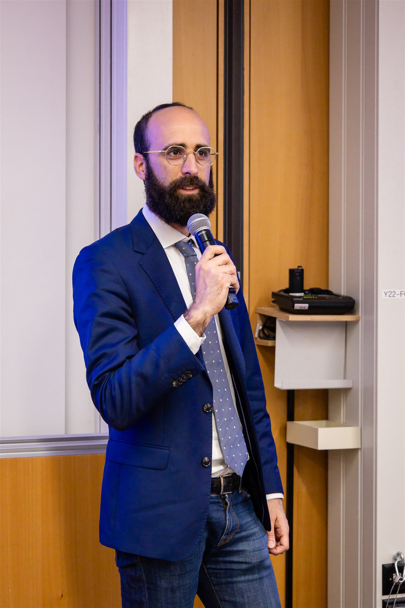 Speaker presenting with microphone at University of Zurich during EthereumZüri
